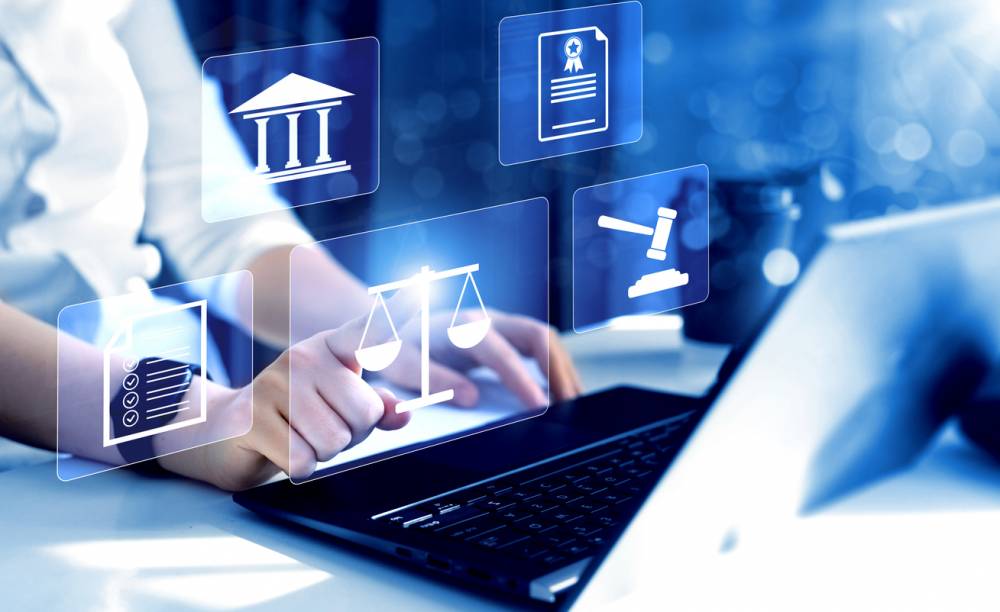 Mains consultant un dossier juridique numérique sur tablette avec document papier à proximité